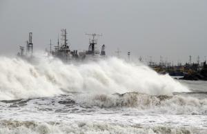 A big wave smashes into a breakwater at a fishing harbour in Jalaripeta in the Visakhapatnam district in the southern Indian state of Andhra Pradesh October 11, 2013. Tens of thousands fled their homes in coastal areas of eastern India and moved to shelters on Friday, bracing for the fiercest cyclone to threaten the country since a devastating storm killed 10,000 people 14 years ago. REUTERS/Stringer (INDIA - Tags: DISASTER ENVIRONMENT)